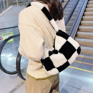 Detail of black and white checkerboard plush shoulder bag with soft faux fur texture