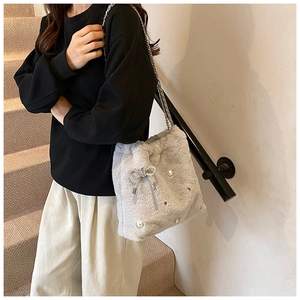 Détail du sac seau en peluche gris clair avec chaîne argentée et décorations perles