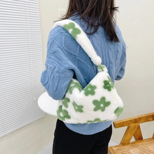 Plush shoulder bag with green flower pattern shown with casual outfit in a home setting