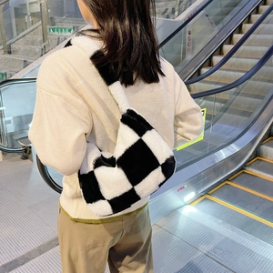 Close-up of black and white checkerboard plush shoulder bag on a model's shoulder