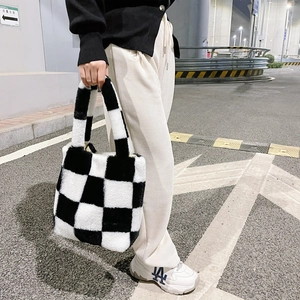 Detailed view of checkered plush tote bag with soft texture in outdoor street setting