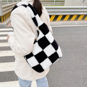 Détail de la texture du sac cabas en peluche à damier noir et blanc sur l'épaule