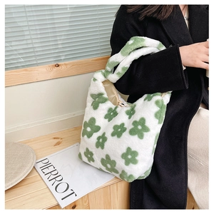 Détail d'un sac à main en peluche à fleurs vertes avec une texture douce en fausse fourrure