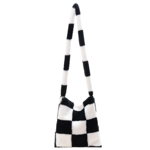 Close-up of fluffy black and white checkerboard plush tote bag with soft faux fur texture