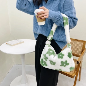 Detailed close-up of plush floral shoulder bag featuring green flower patterns and soft texture