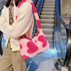 Détail du sac à épaule en peluche rose avec motif cœur et texture en fausse fourrure