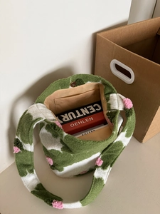 Detailed interior of plush camo tote bag with pink pompoms and internal pocket
