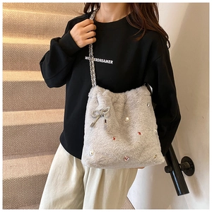Vue détaillée du sac cabas en peluche gris clair avec perles, strass et chaîne en métal