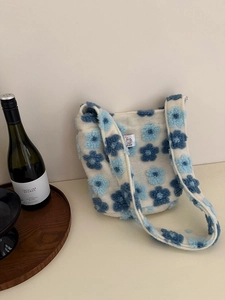 Detail of soft plush tote bag with blue flower patterns and comfortable shoulder strap