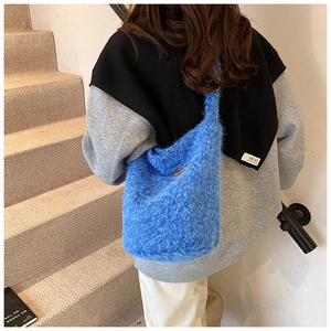 Détail du sac seau bleu électrique en peluche douce avec texture fausse fourrure et étiquette
