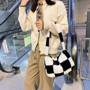 Detail of plush black and white checkered tote bag showing soft texture and wide strap