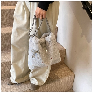 Détail du sac seau en fausse fourrure gris clair avec nœud strass et perles