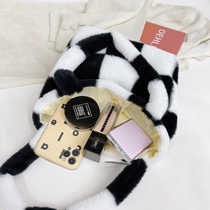 Spacious interior of checkered plush handbag holding cosmetics and mobile phone