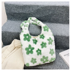 Détail d'un sac à main en peluche blanche avec motifs floraux verts et boucle en métal doré