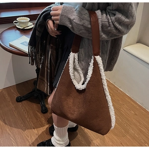 Dettaglio della borsa tote in pelle scamosciata marrone con bordo in finto montone bianco