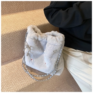 Détail du sac à bandoulière en fausse fourrure grise avec nœud strass et chaîne argentée