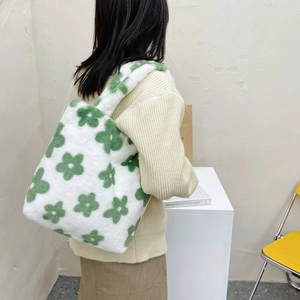 Detail of white plush flower tote bag showing the carrying size on a model's back