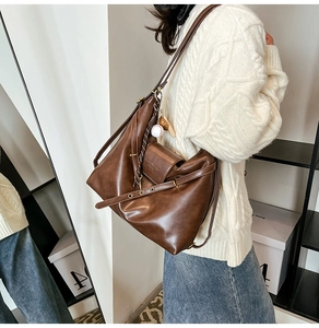 Close-up of vintage brown large tote bag with brand embossing and adjustable strap