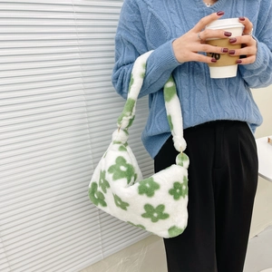Detail view of plush green floral handbag with soft texture and white shoulder strap