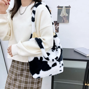 Detail of plush faux fur tote bag with black and white cow print texture for winter