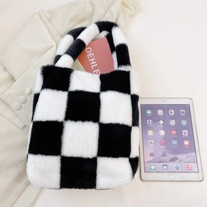 Detail view of the black and white checkered plush handbag showing soft texture and capacity