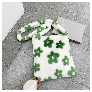 Vue détaillée d'un sac à bandoulière en peluche à motif floral vert sur fond de pierre