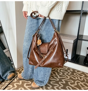 Detail view of large dark brown retro tote bag with teddy charm and dual straps