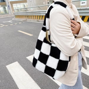 Détail de la texture pelucheuse à damier noir et blanc sur un sac cabas élégant et doux