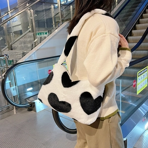 Photo de rue d'un sac à bandoulière en peluche avec motif de vache noir et blanc tendance
