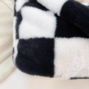 Close-up of black and white checkered plush fabric texture on a soft handbag
