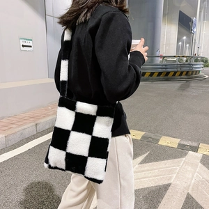 Detailed view of plush black and white checkerboard tote bag with wide shoulder strap