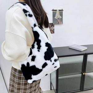 Detail of plush faux fur shoulder bag featuring black and white cow print texture