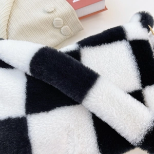 Close-up detail of plush black and white checkerboard pattern on the faux fur handbag