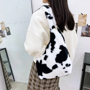 Detail of soft plush cow print shoulder bag showing fluffy faux fur texture and pattern