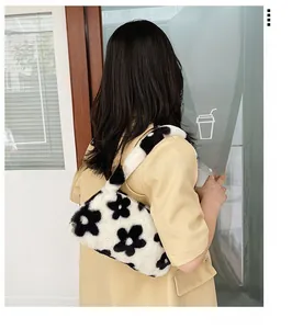 Detailed view of the fuzzy floral shoulder bag worn by a model in a trendy setting