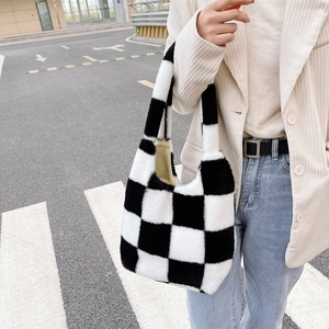 Détail d'un sac cabas en peluche à damier montrant la texture douce et le motif noir et blanc