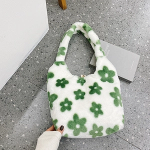 Vista dall'alto di una borsa tote in peluche bianca con grandi motivi floreali verdi soffici