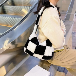Close-up of plush black and white checkerboard shoulder bag with soft faux fur texture
