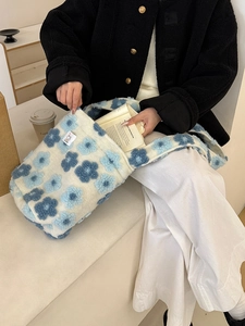 Close-up of soft plush fabric texture and blue floral pattern on shoulder bag