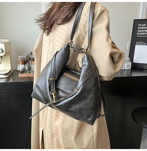 Detail of black PU leather bag showing pleated texture and gold metal buckle accents