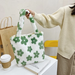 Close-up of fluffy plush tote bag featuring green flower patterns and soft texture