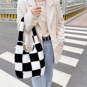 Gros plan détaillé d'un sac à main en peluche à damier noir et blanc pour l'hiver