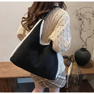 Dettaglio borsa hobo in camoscio nero con finiture in pelliccia sintetica bianca