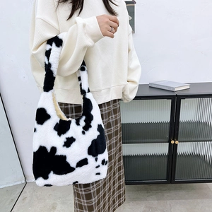 Close-up of fluffy cow print plush tote bag with soft texture and shoulder handle detail