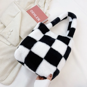 Detailed close-up of the plush black and white checkered faux fur tote handbag texture