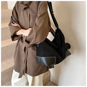 Detail of black contrast stitch tote bag featuring premium leather trim and large capacity