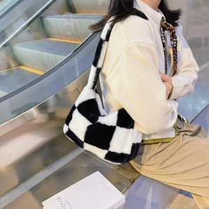 Close-up of black and white checkered plush shoulder bag with soft fuzzy texture on a model