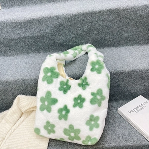 Dettaglio della borsa tote in morbido peluche con motivi floreali verdi e fodera