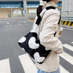 Détail du sac à main en peluche noir et blanc avec motif cœur en vue extérieure
