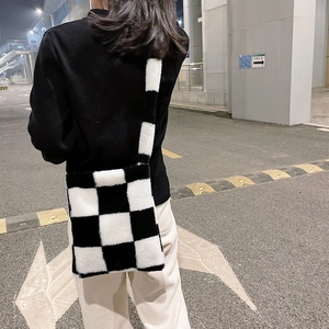 Detailed close-up showing the soft plush texture of the black and white checkered crossbody bag